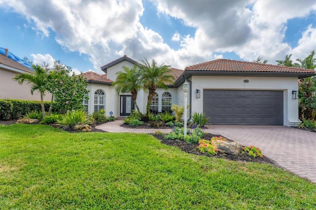 mediterranean / spanish-style house with a garage and a front lawn