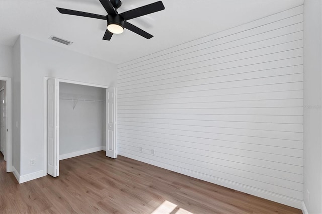 unfurnished bedroom with ceiling fan, a closet, and light hardwood / wood-style flooring