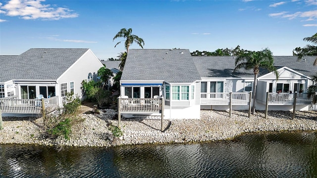 rear view of house with a water view and a patio area