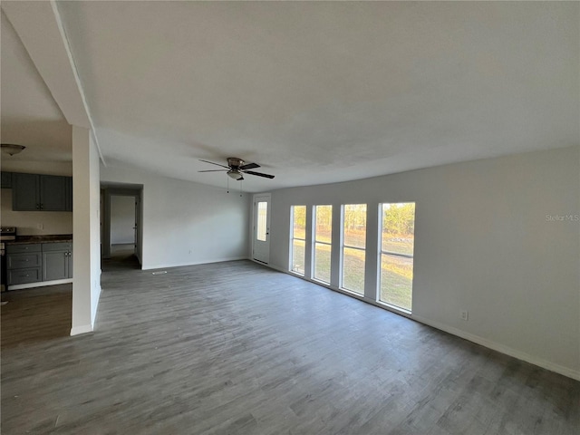 unfurnished living room with wood-type flooring and ceiling fan