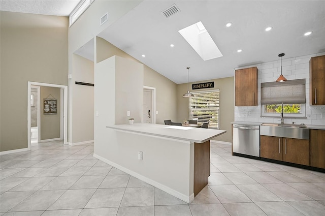 kitchen featuring hanging light fixtures, sink, dishwasher, light tile patterned floors, and a skylight