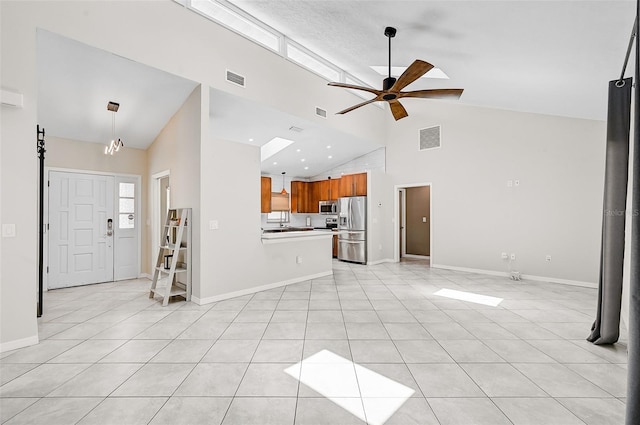 unfurnished living room with high vaulted ceiling, light tile patterned floors, and ceiling fan