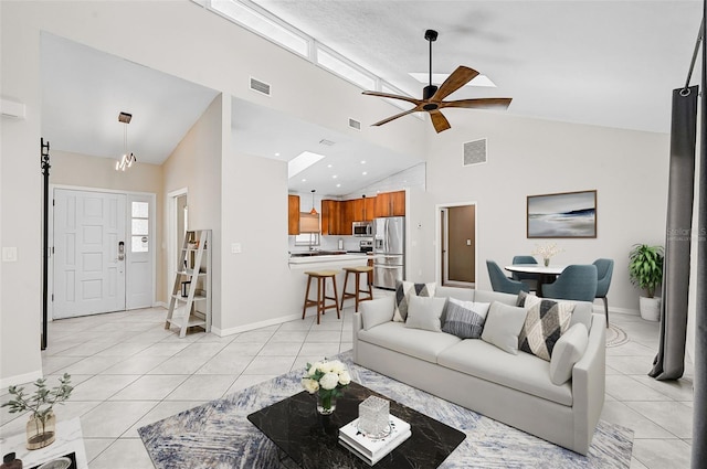 tiled living room with ceiling fan and high vaulted ceiling