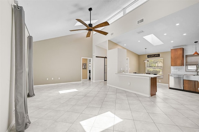 kitchen featuring backsplash, dishwasher, ceiling fan, light tile patterned floors, and a skylight