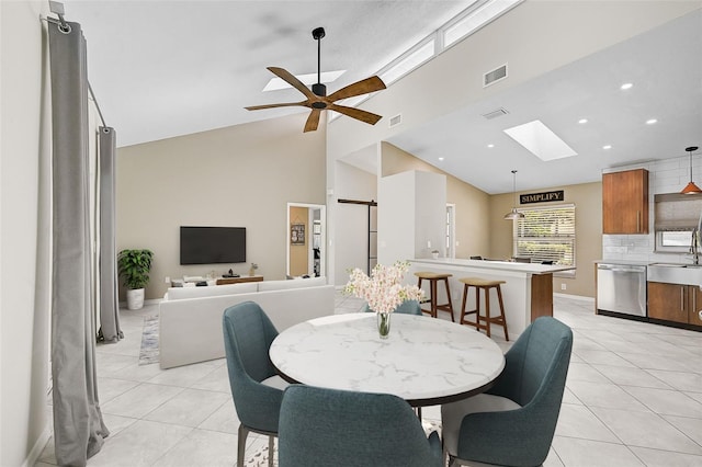 tiled dining room featuring ceiling fan, sink, and high vaulted ceiling