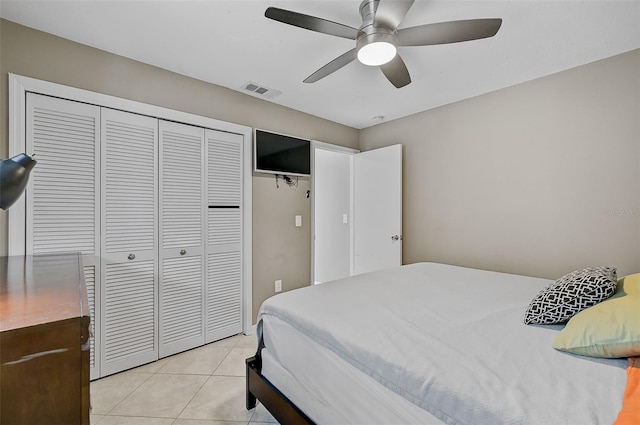 bedroom with light tile patterned flooring, a closet, and ceiling fan