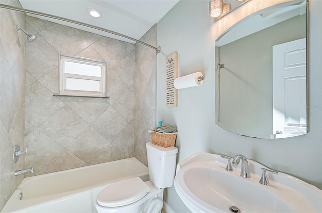 full bathroom featuring tiled shower / bath combo, sink, and toilet