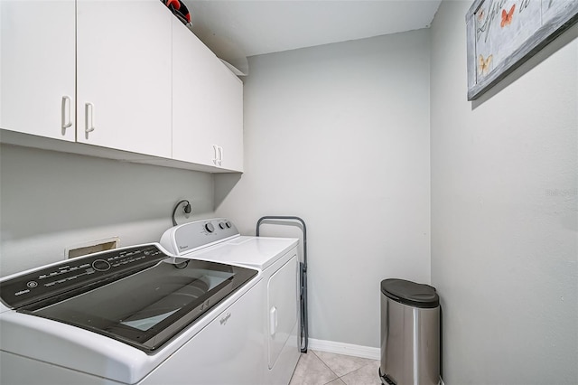 laundry room with cabinets, washer and dryer, and light tile patterned floors