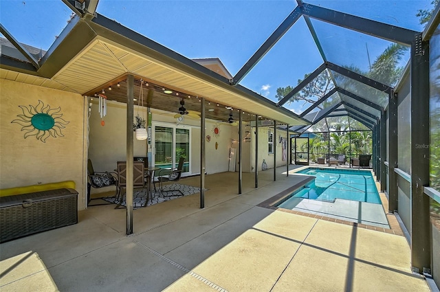 view of pool with a patio, glass enclosure, and ceiling fan