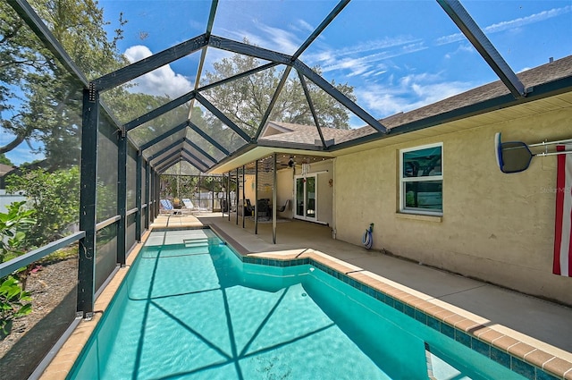 view of swimming pool with a patio, a lanai, and ceiling fan