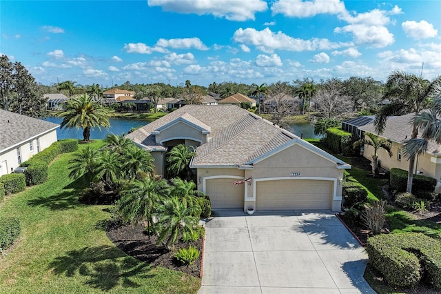 view of front of house with a garage and a water view