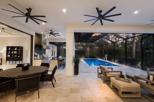 19424 Ganton Ave, Lakewood Ranch, FL 34202 - pool featuring exterior kitchen, outdoor dining area, a patio area, a ceiling fan, and glass enclosure