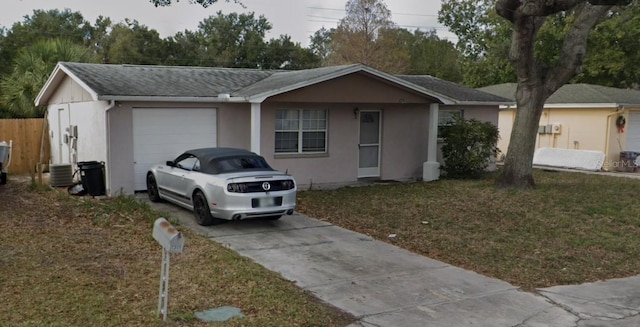 single story home with central AC unit, a garage, and a front yard