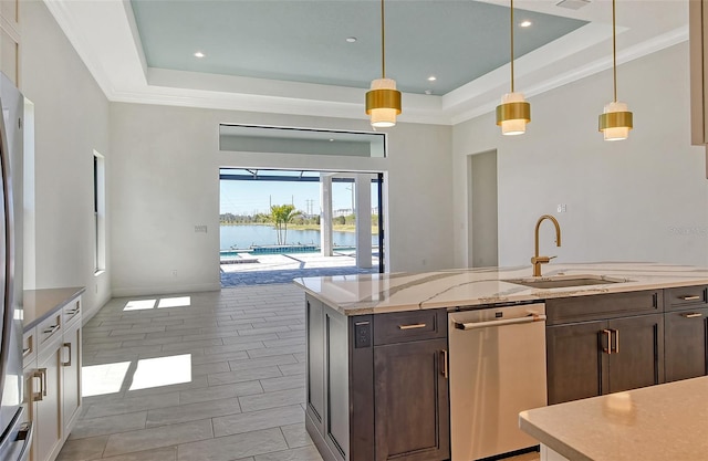 552 Bocelli Dr, North Venice, FL 34275 - kitchen featuring a tray ceiling, dark brown cabinets, light stone countertops, and a sink