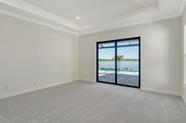 552 Bocelli Dr, North Venice, FL 34275 - empty room featuring light colored carpet, a tray ceiling, baseboards, and a water view