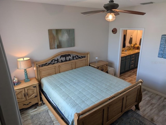 bedroom featuring ensuite bathroom and light wood-type flooring