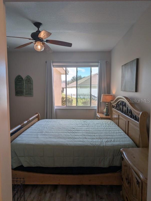 bedroom with dark hardwood / wood-style floors and ceiling fan