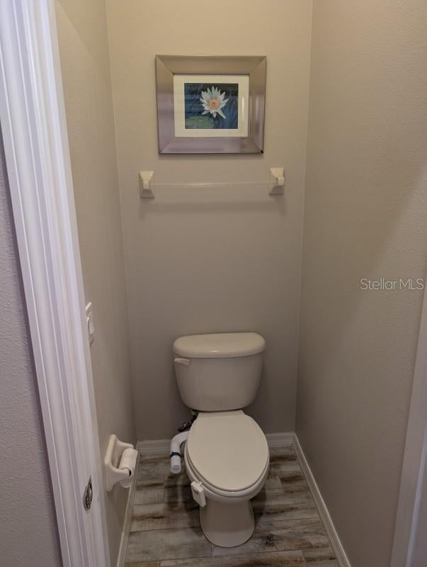 bathroom featuring hardwood / wood-style flooring and toilet