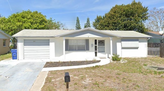 ranch-style house featuring a garage, covered porch, driveway, and stucco siding