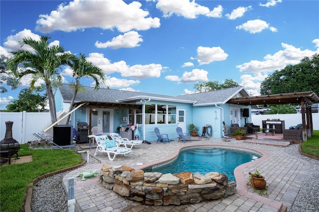 rear view of house featuring a fenced in pool and a patio