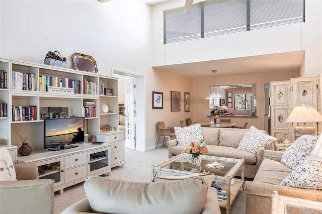 living room featuring a high ceiling and light colored carpet