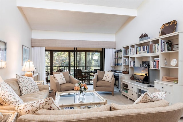 living room with light carpet, beam ceiling, and high vaulted ceiling