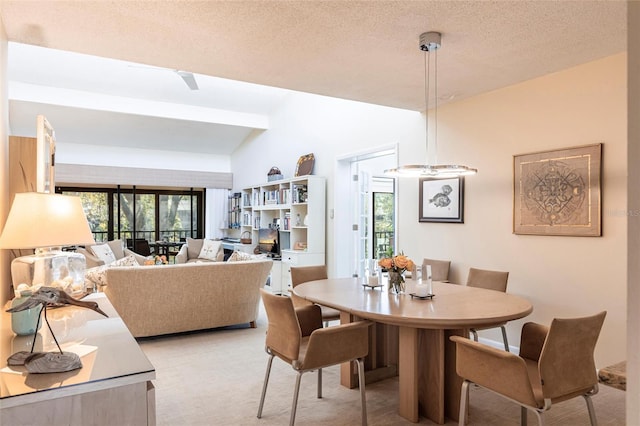 carpeted dining space featuring lofted ceiling with beams and a textured ceiling