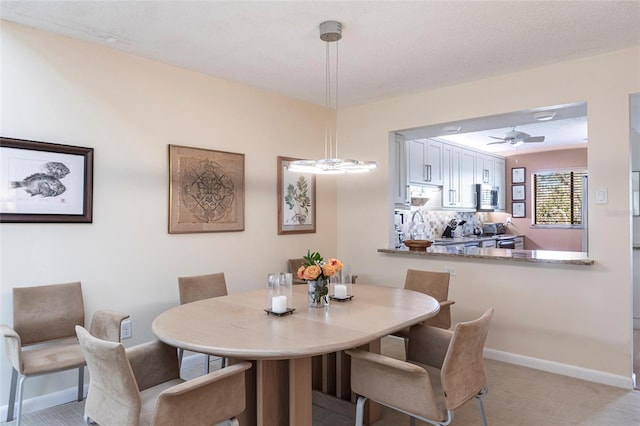 carpeted dining room with ceiling fan and sink