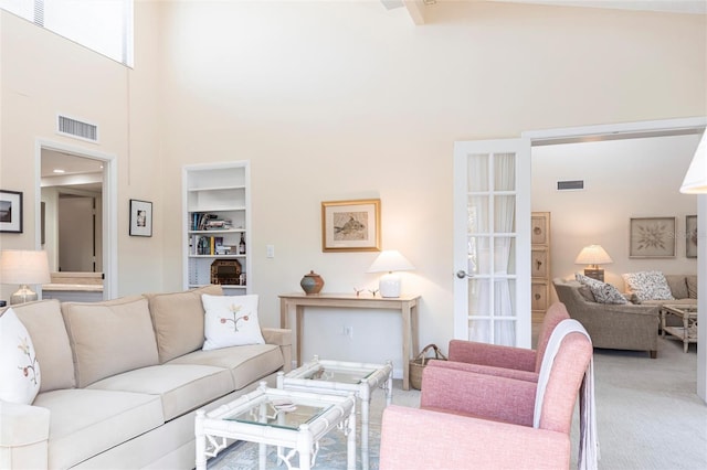 carpeted living room featuring a towering ceiling