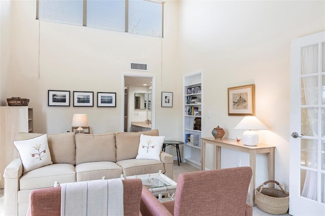 living room with a towering ceiling and built in features