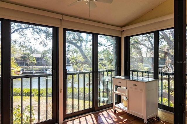 sunroom / solarium featuring vaulted ceiling and a water view