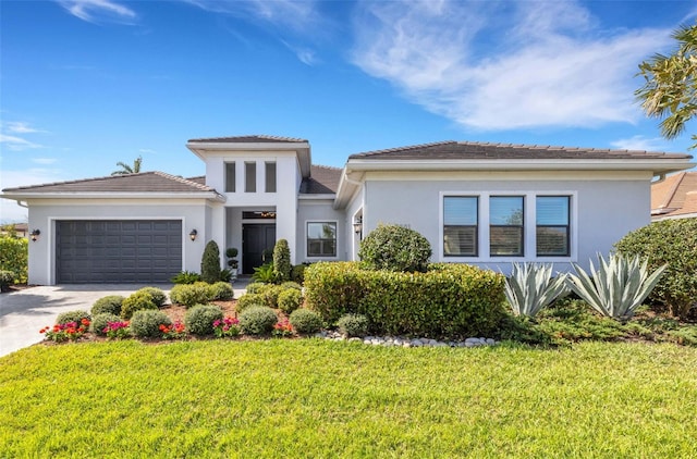 prairie-style home with a garage, driveway, a front yard, and stucco siding