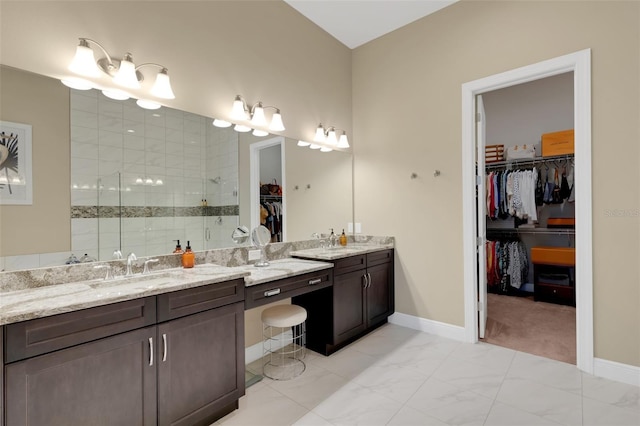 bathroom with a stall shower, baseboards, marble finish floor, a spacious closet, and vanity