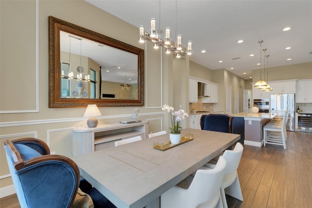 dining room featuring an inviting chandelier, wood finished floors, and recessed lighting