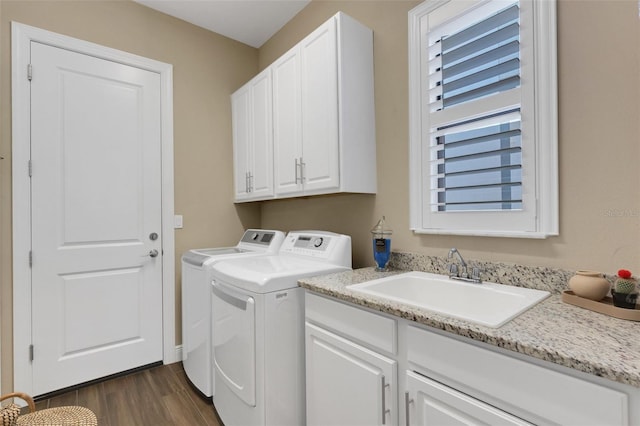 washroom with separate washer and dryer, dark wood-style flooring, a sink, and cabinet space