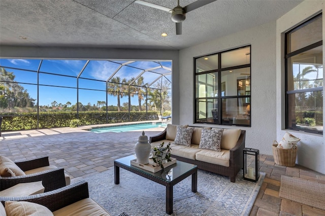 view of patio / terrace with an outdoor pool, glass enclosure, ceiling fan, and outdoor lounge area