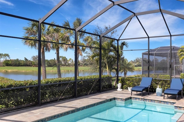 outdoor pool featuring a water view, glass enclosure, and a patio