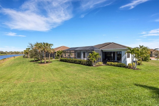 view of front of house with a lanai, a water view, and a front lawn