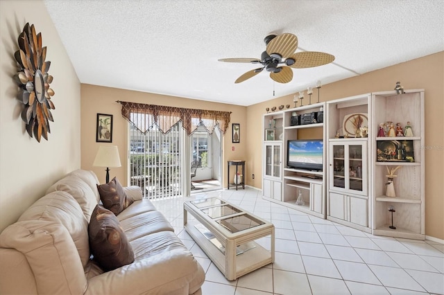 living room with light tile patterned flooring, ceiling fan, and a textured ceiling