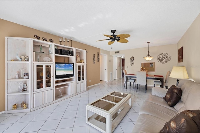 living room featuring a textured ceiling, ceiling fan, and light tile patterned flooring