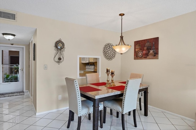 tiled dining space featuring a textured ceiling