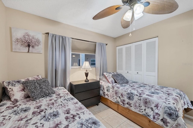 bedroom with light tile patterned floors, ceiling fan, and a closet