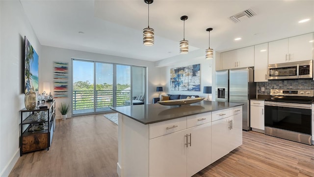 kitchen with stainless steel appliances, visible vents, white cabinets, hanging light fixtures, and dark countertops