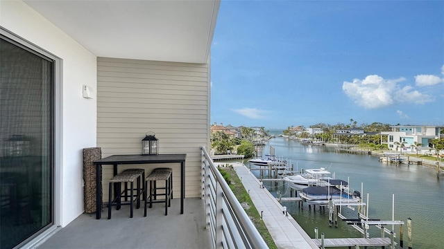 balcony featuring a dock, a water view, and boat lift