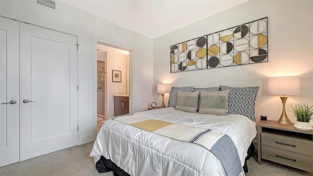 bedroom with connected bathroom, visible vents, and light colored carpet