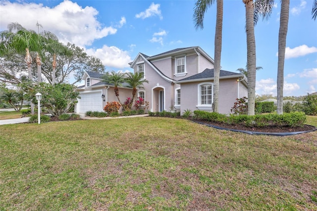 view of property with a garage and a front lawn