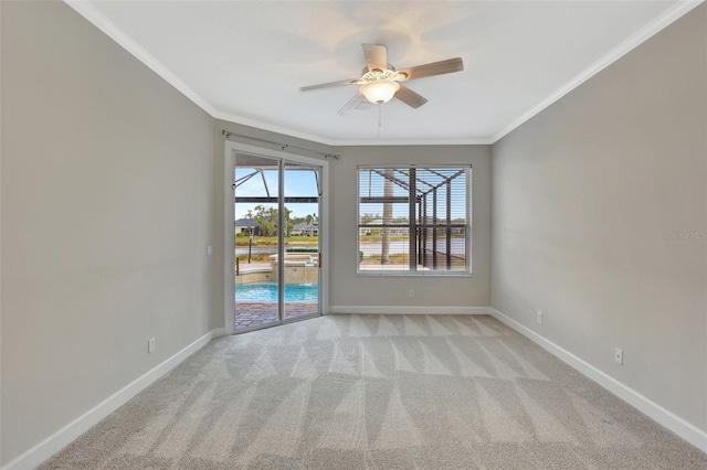 carpeted spare room featuring ceiling fan and ornamental molding