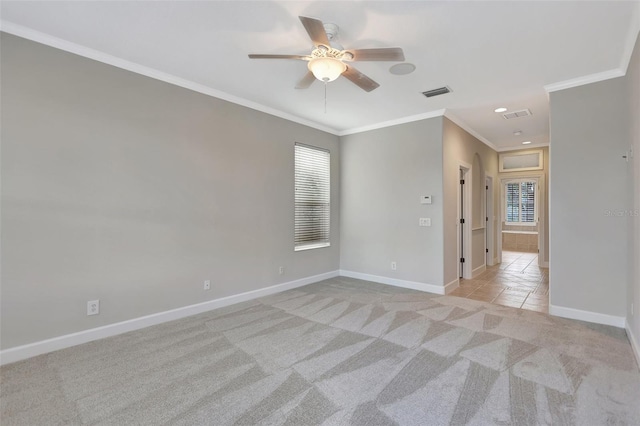 spare room featuring crown molding, ceiling fan, and light carpet