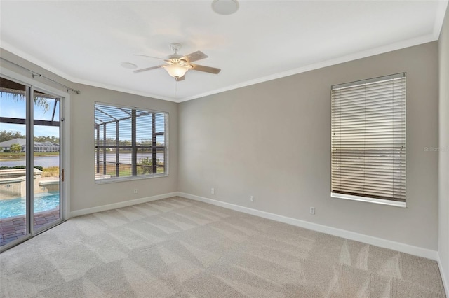 unfurnished room with ceiling fan, light colored carpet, and ornamental molding