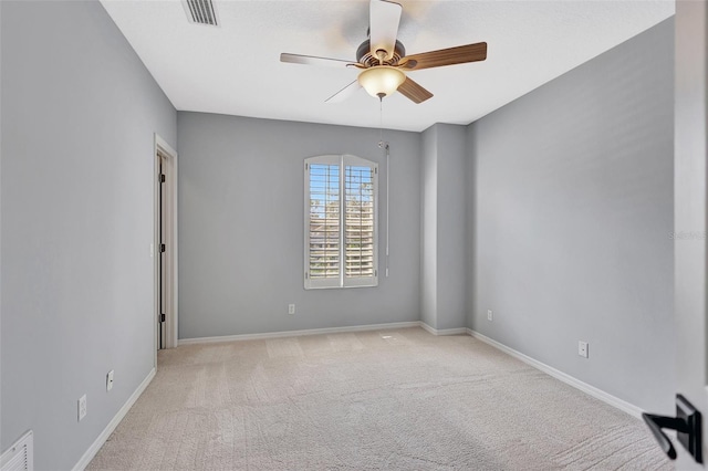 empty room featuring light colored carpet and ceiling fan